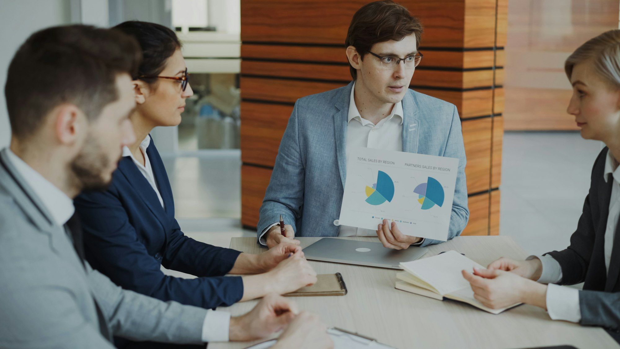 A hiring manager reviewing charts and notes with a colleague at a desk